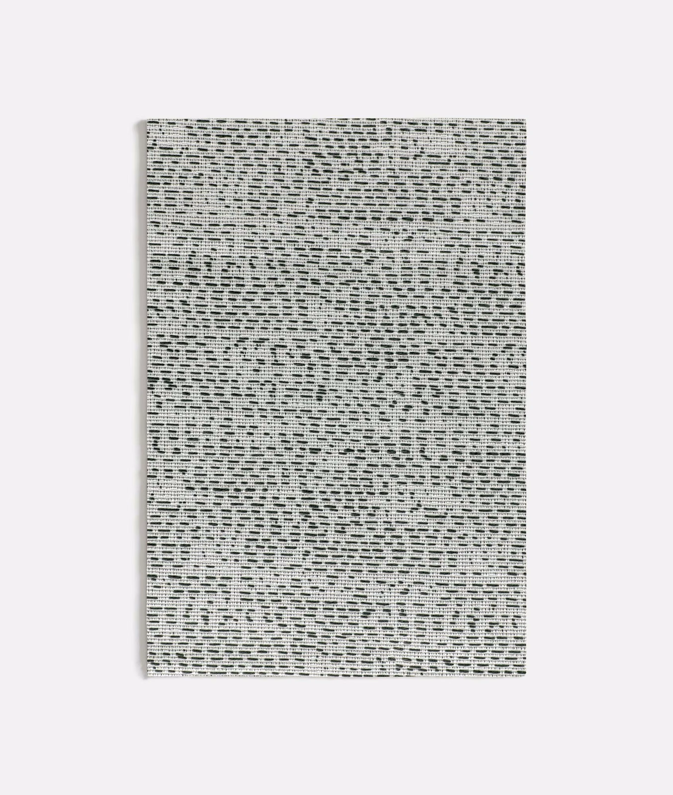 Pale grey woven textile with dense black broken dashes and irregular texture