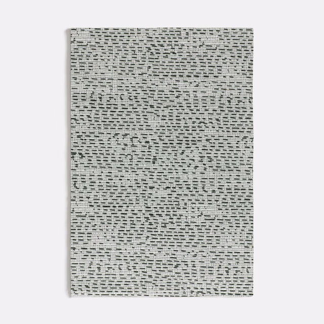 Pale grey woven textile with dense black broken dashes and irregular texture