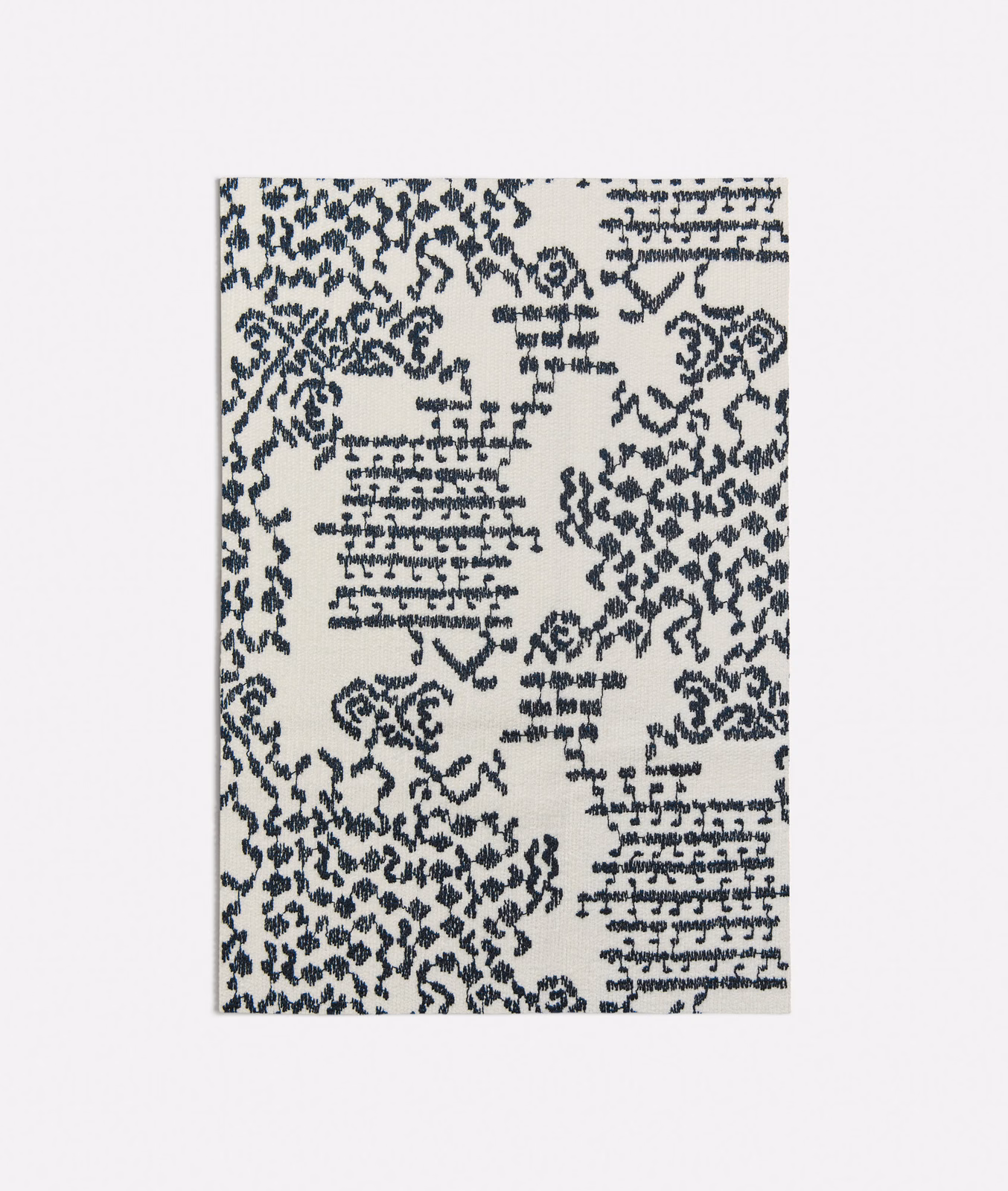 Ink-blue distressed botanical and geometric motifs scattered across a cream woven ground