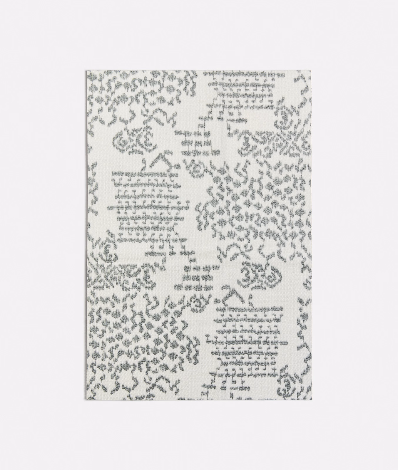 Pale seafoam fabric with grey script-like marks and distressed ornamental clusters