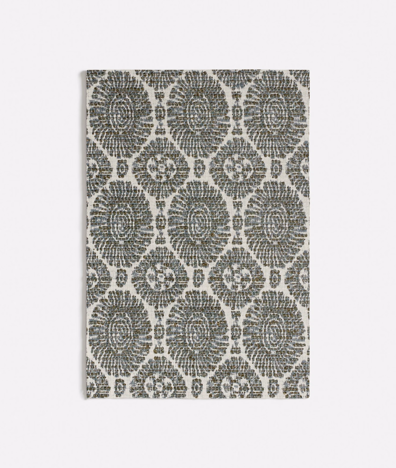 Muted seafoam fabric with charcoal floral medallions in a textured repeating weave