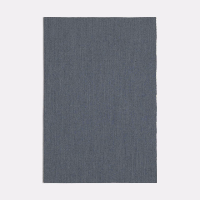 Muted blue-grey fabric swatch with fine vertical grain and softly mottled texture