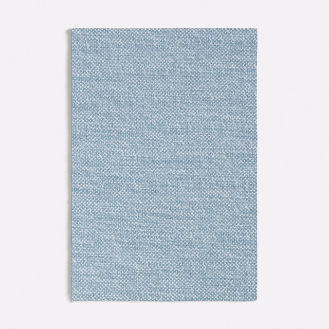 Pale blue textile swatch with a fine, softly flecked woven texture