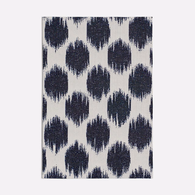 Ivory woven fabric with repeating deep ink-blue frayed diamond motifs
