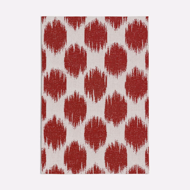Deep red brush-edged ikat-style motifs woven across an ivory ground