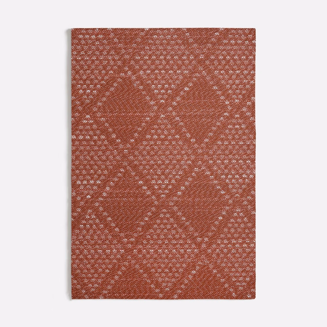 Rust terracotta woven swatch with pale flecked diamond lattice and tactile texture