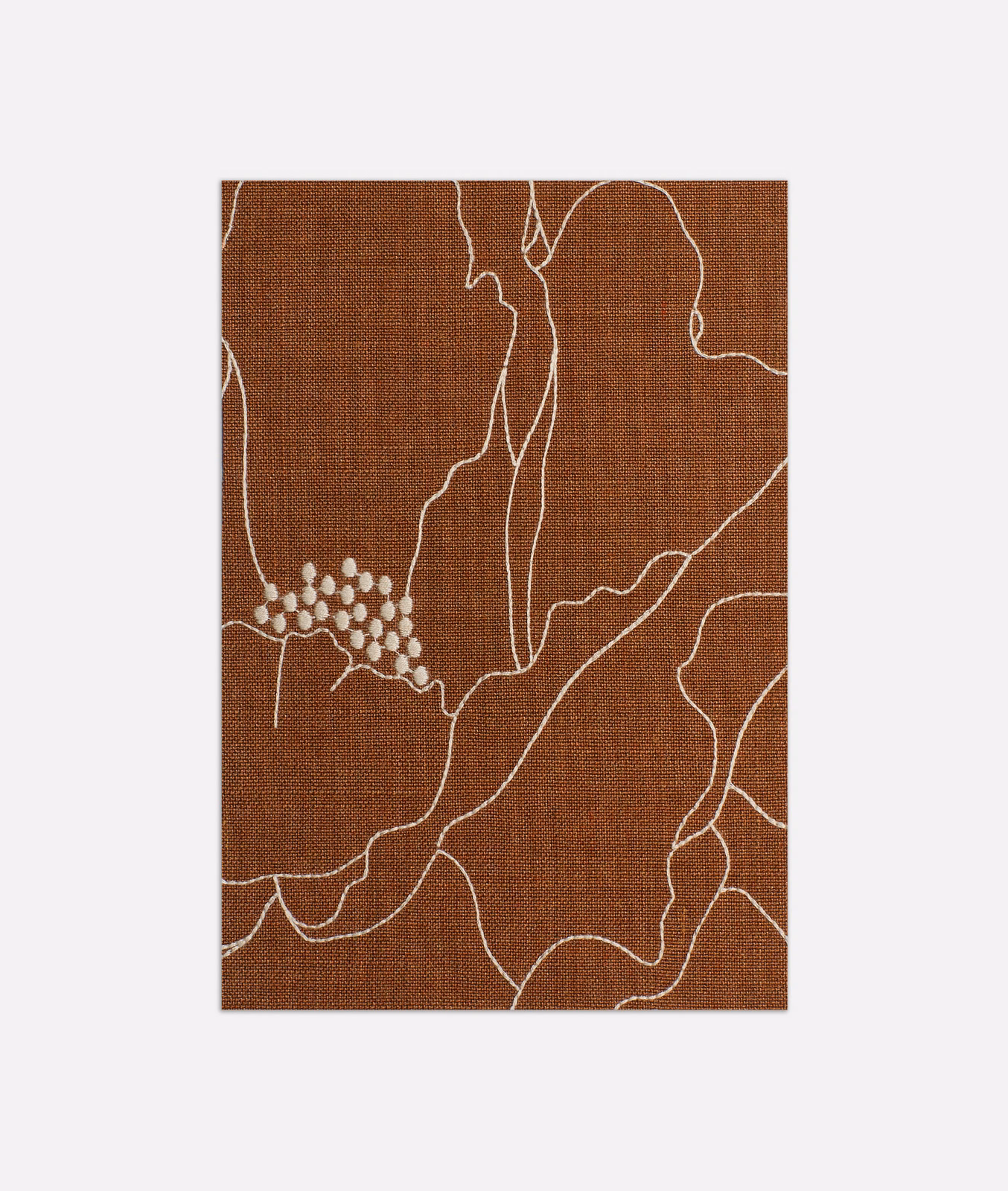 Warm terracotta woven swatch with ivory abstract contours and a small dotted cluster