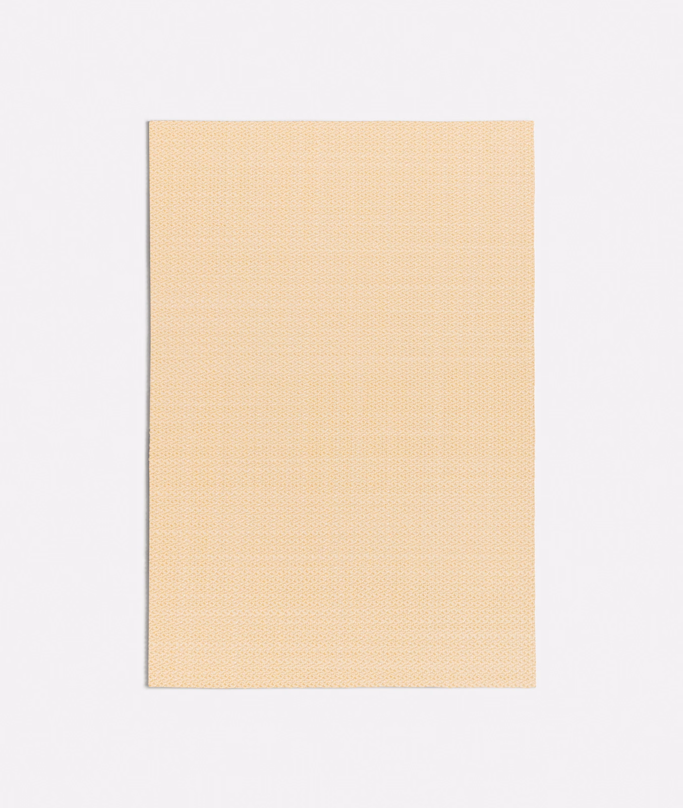 Close view of pale papaya-yellow fabric with a fine, even woven surface