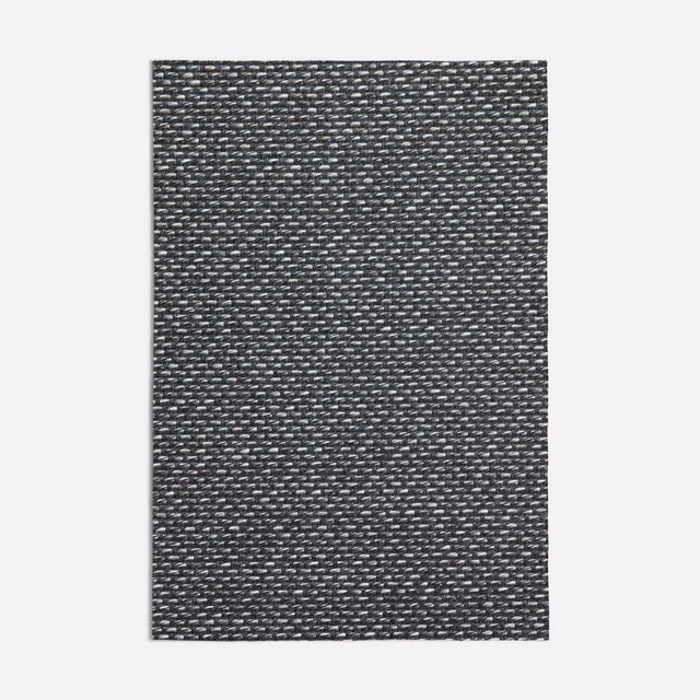 Close view of charcoal-grey woven textile with fine silver-grey flecks