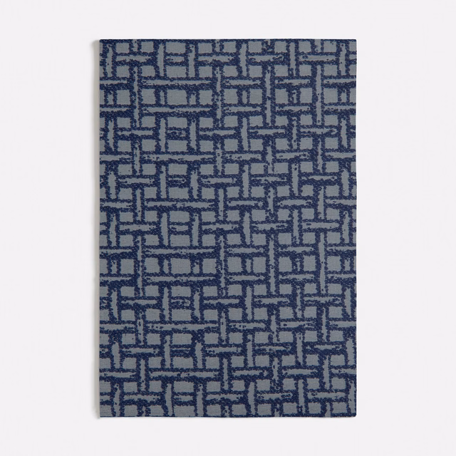 Blue-grey woven swatch with navy interlocking rectangles and subtly raised texture