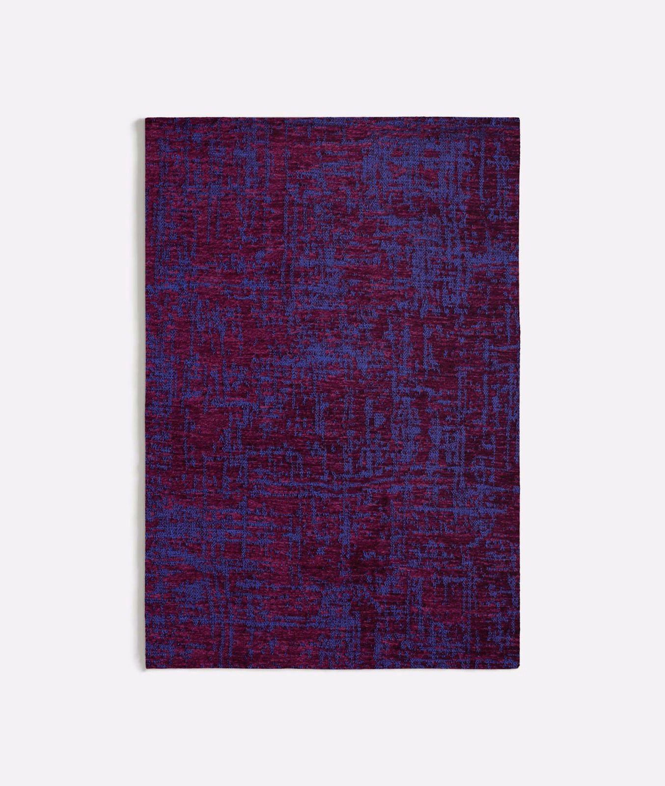 Deep purple textile with blue and burgundy threads in a distressed abstract grid weave