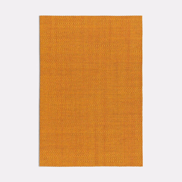 Warm burnt orange fabric with a dense tiny check weave and subtle golden tonal variation
