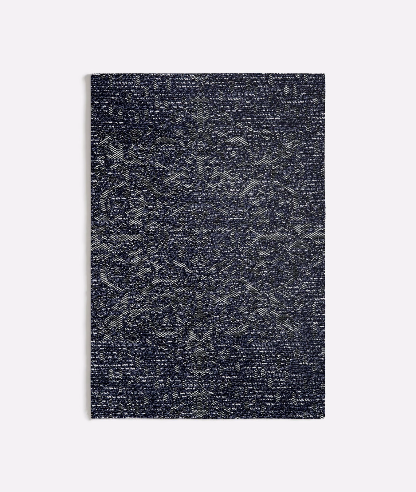 Dense blue-grey weave with shadowed medallions and flecked surface texture