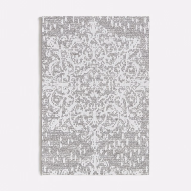 Cool grey textile with white scrolling medallion, mottled ground, and distressed flecks