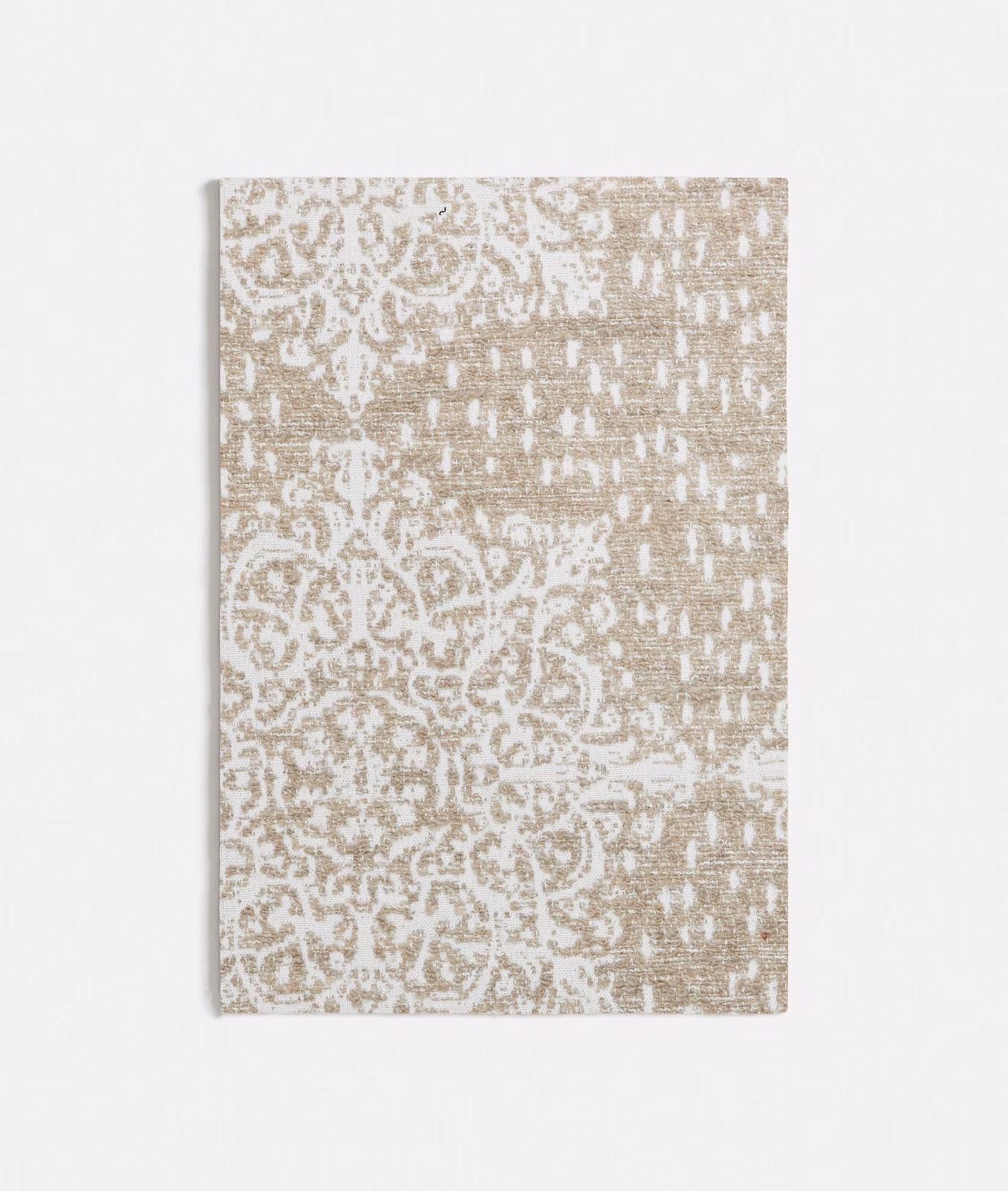 Weathered taupe beige textile with distressed ivory medallions and a nubby woven surface