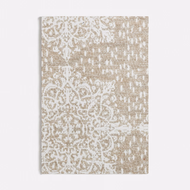 Weathered taupe beige textile with distressed ivory medallions and a nubby woven surface