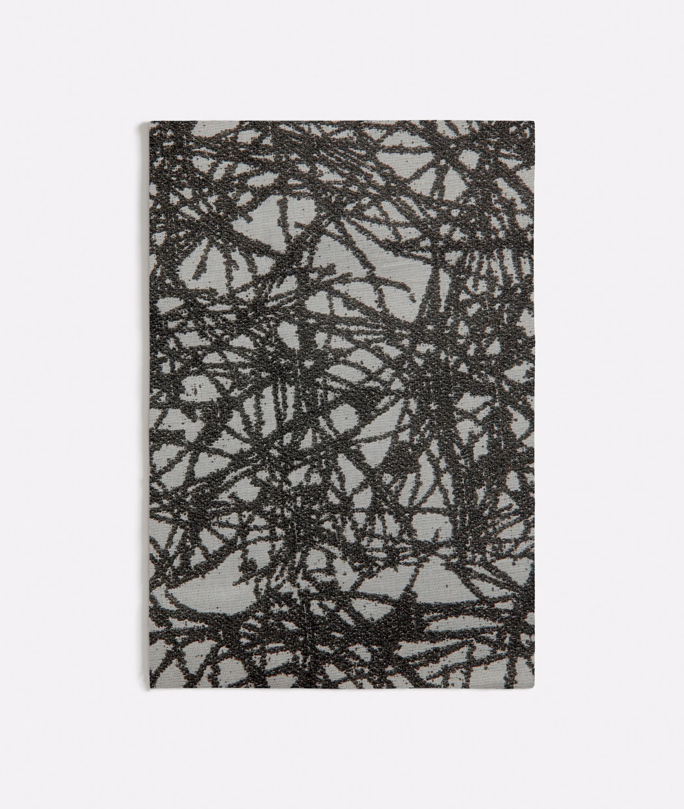 Charcoal-grey textile with dense black scribble lines and raised texture