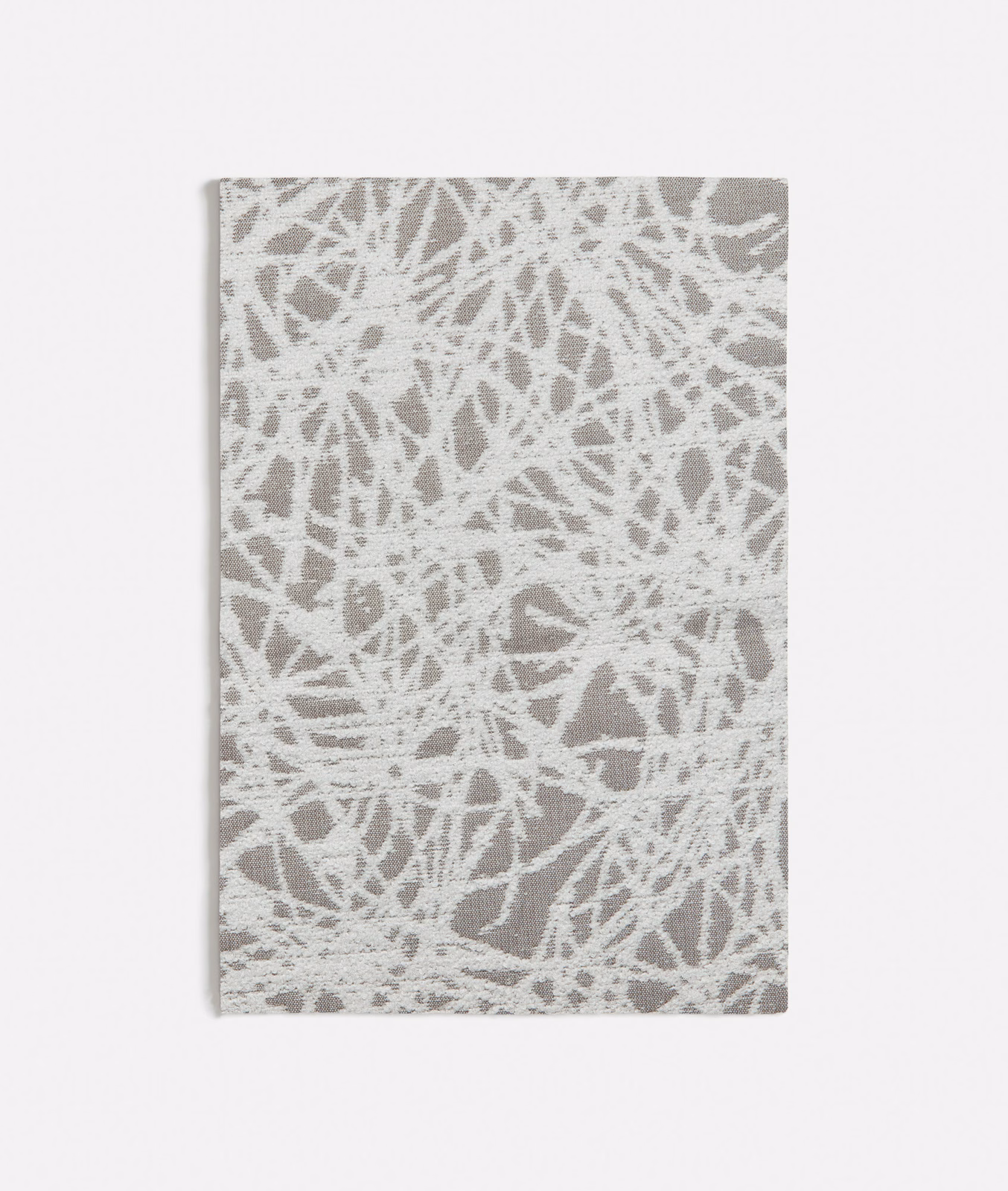 Chalky white and grey woven swatch with dense irregular scratch marks and textured surface