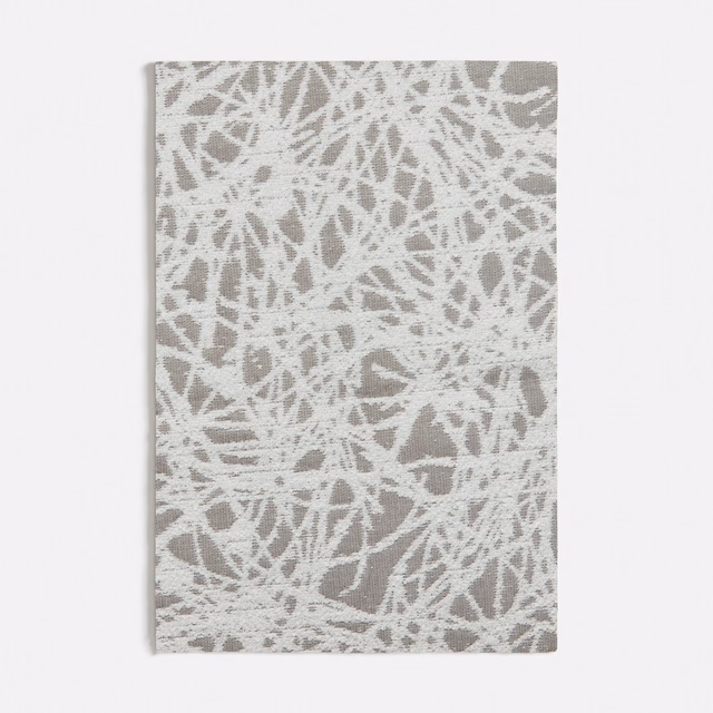 Chalky white and grey woven swatch with dense irregular scratch marks and textured surface