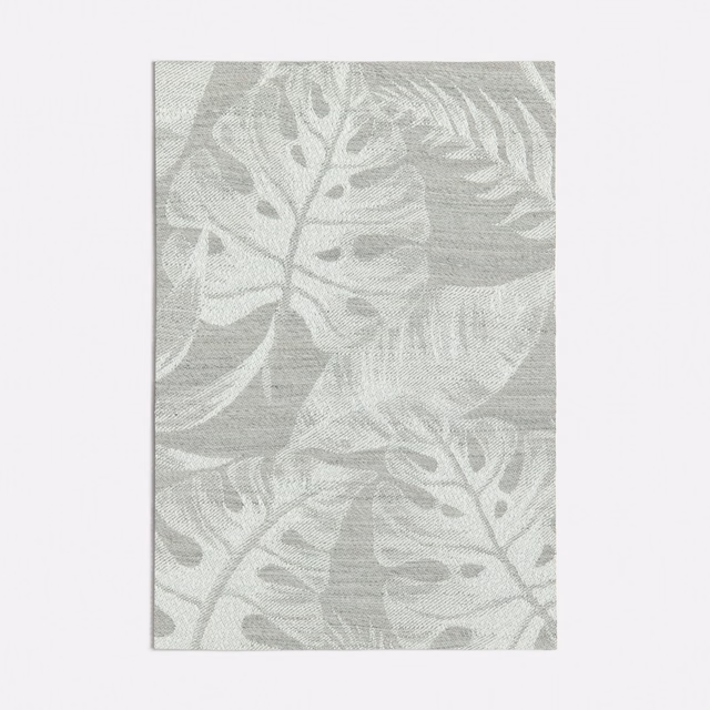 Pale grey woven fabric with oversized botanical leaves and softly layered tonal texture