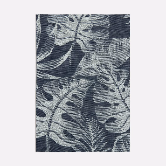 Deep navy woven ground with oversized blue-grey tropical leaves and fine texture