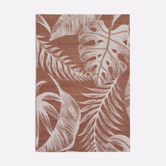 Muted terracotta woven ground with oversized cream tropical leaves and fronds