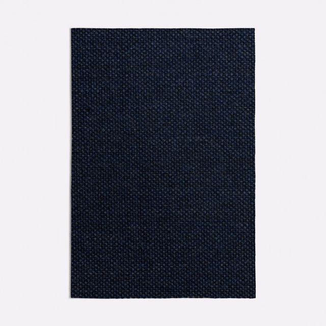 Dense tiny-weave upholstery fabric in deep navy with near-black tonal texture
