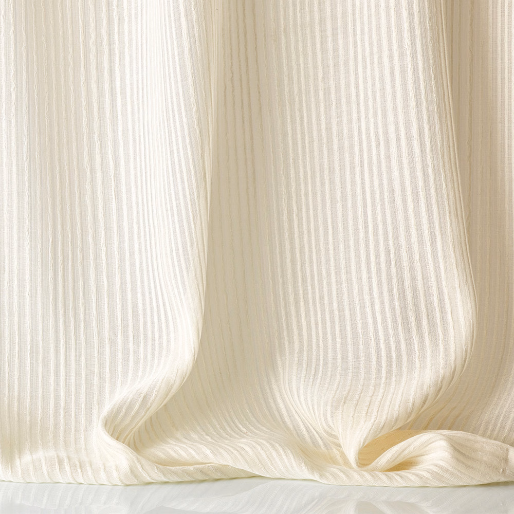 Warm ivory sheer fabric with fine vertical ribs gathered into soft folds