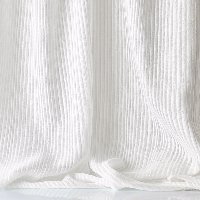 White Annalena fabric with fine vertical ribs pooling in soft folds
