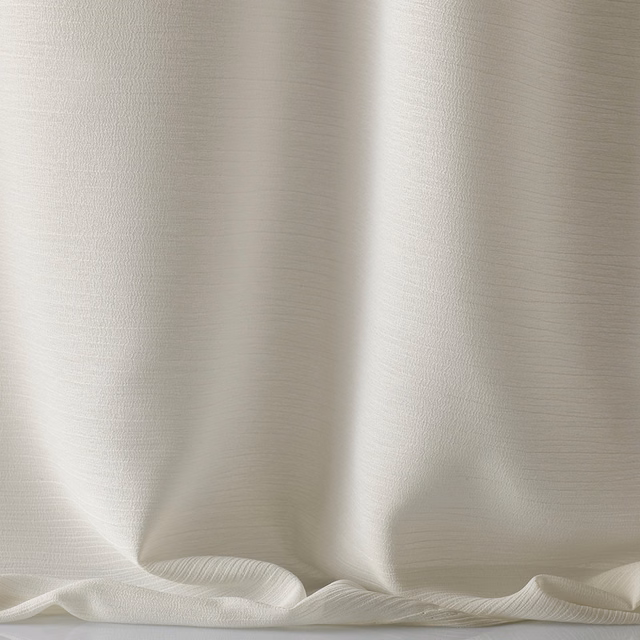 Pale ivory fabric with fine horizontal texture and softly lustrous flowing folds