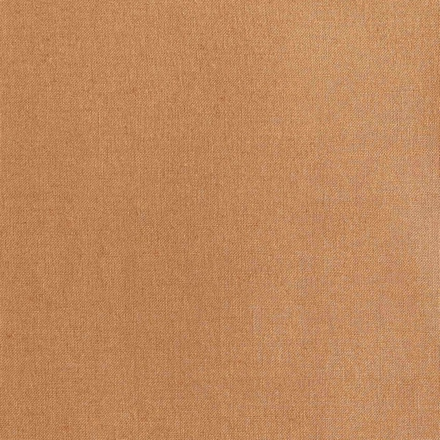 Close-up of warm terra-cotta fabric with a fine, subtly flecked woven surface