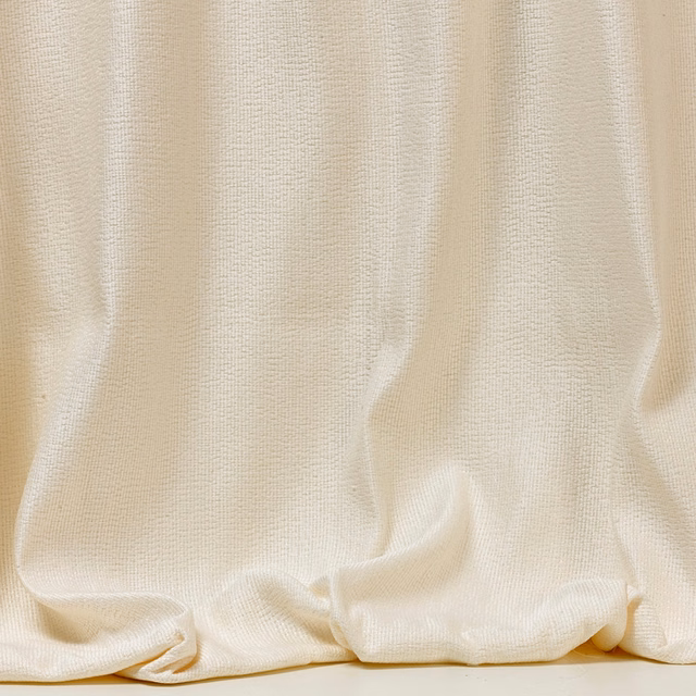 Soft ivory fine-weave fabric gathered into fluid vertical folds with a pooled hem