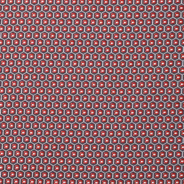 Dense chili-red geometric weave with charcoal outlines and tiny cream accents