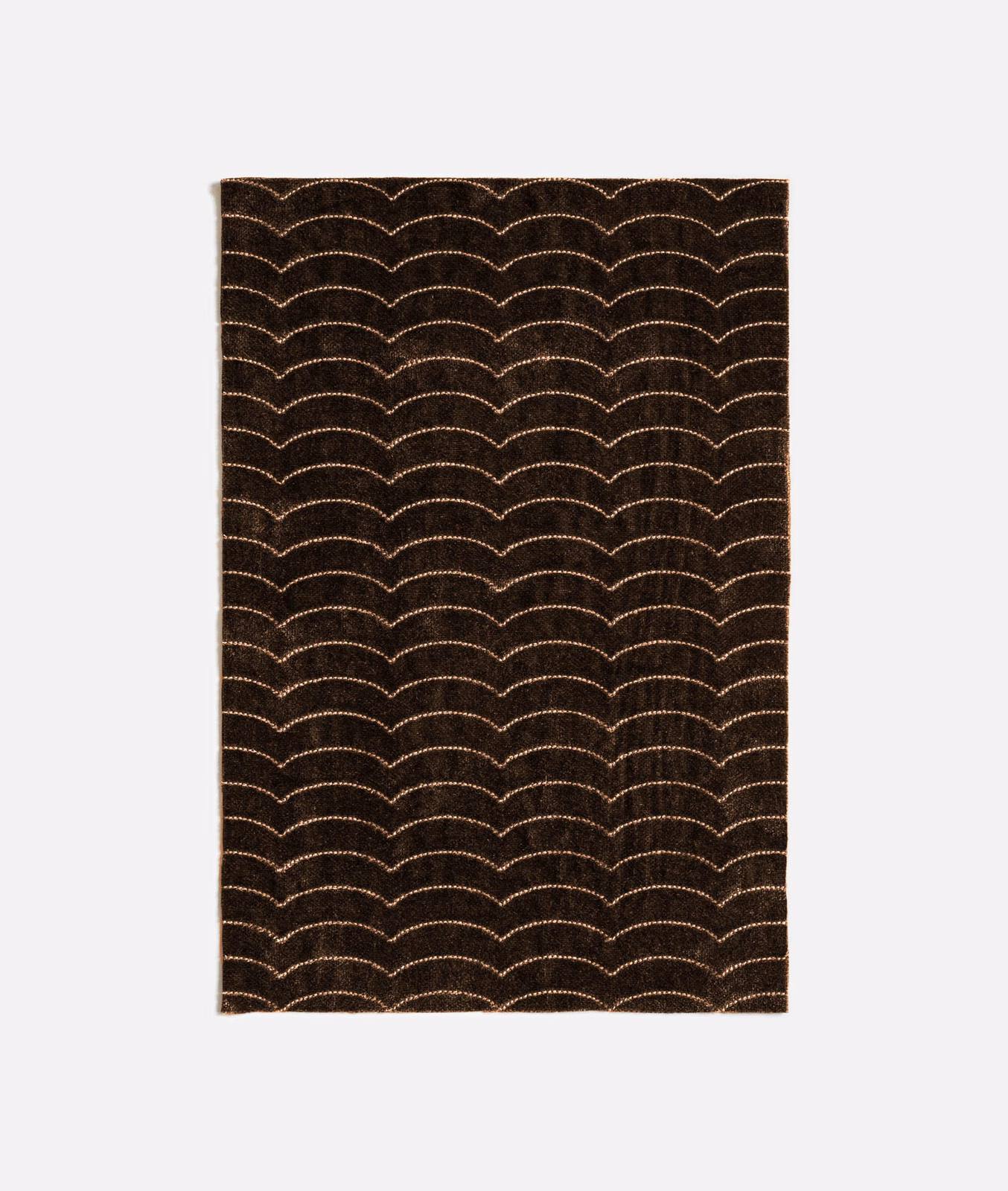 Deep brown-charcoal textile with repeating pale scalloped arcs in a dense surface weave