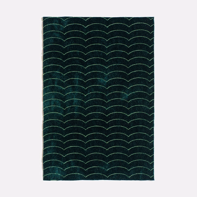 Deep forest green textile with pale green scalloped arcs and a nubby woven texture