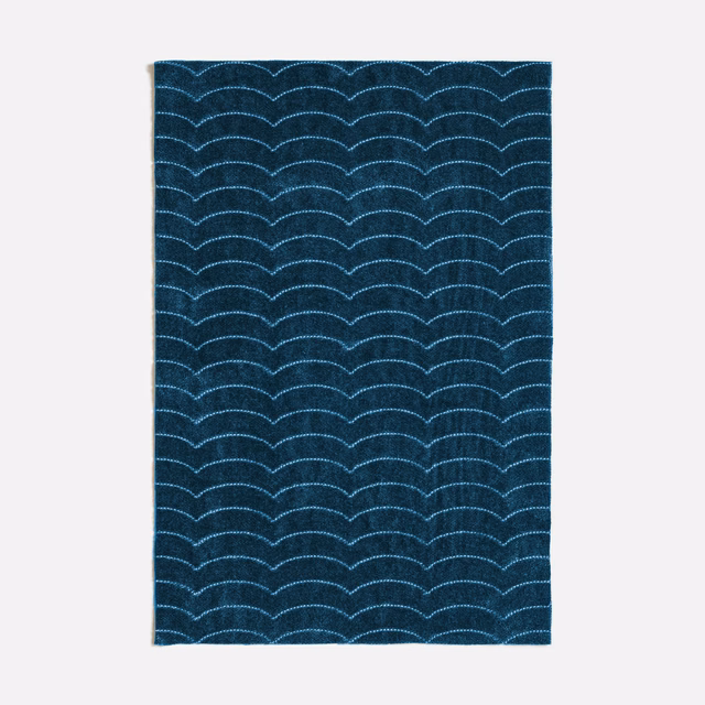 Dark indigo textile with repeated pale blue scallop lines and subtle woven texture