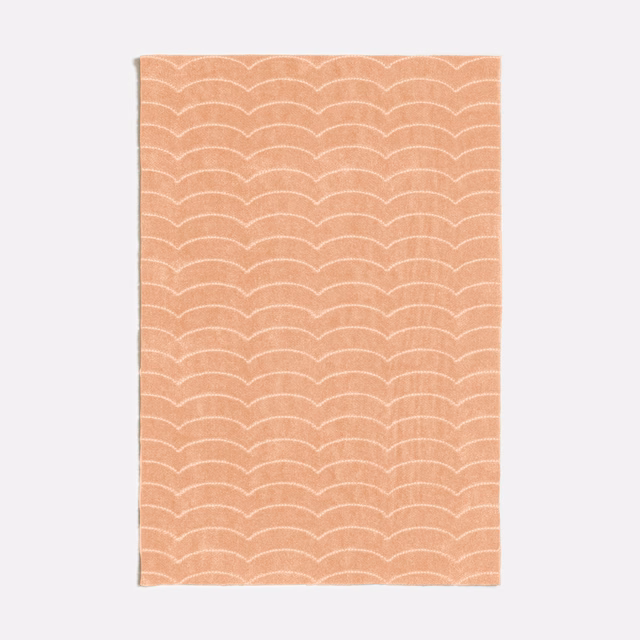 Warm peach-nude swatch with repeated pale scalloped arches and subtle woven texture