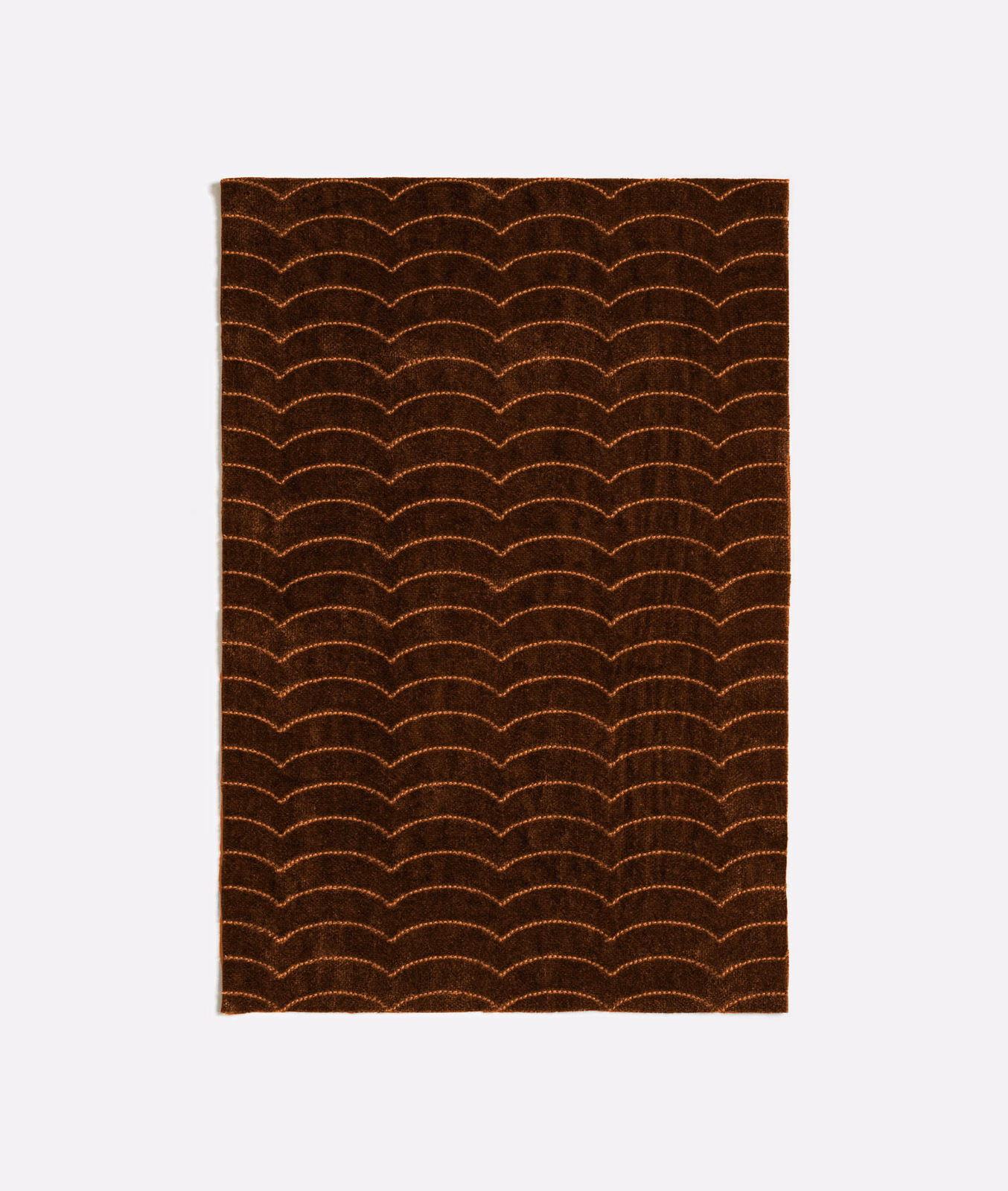 Deep tobacco-brown textile with repeated copper scalloped arches and a subtly textured surface