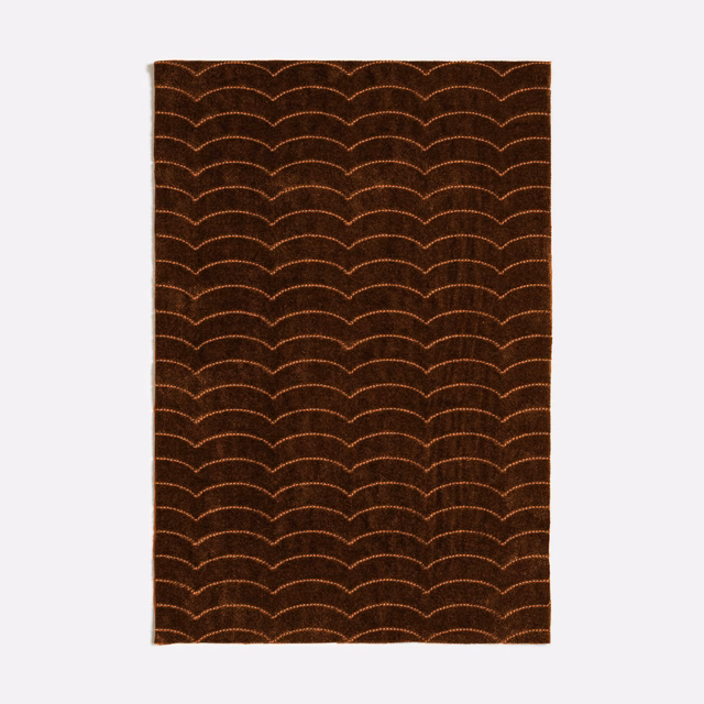 Deep tobacco-brown textile with repeated copper scalloped arches and a subtly textured surface