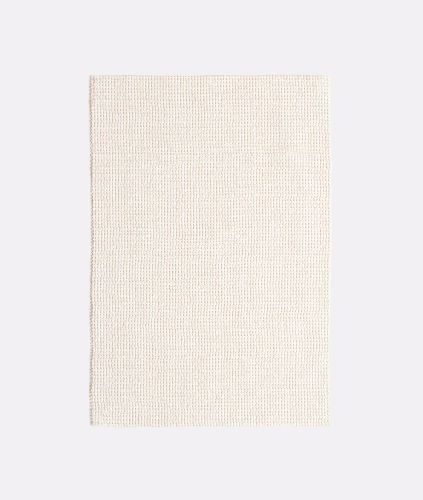Close view of warm ivory fabric with a fine regular woven grid texture