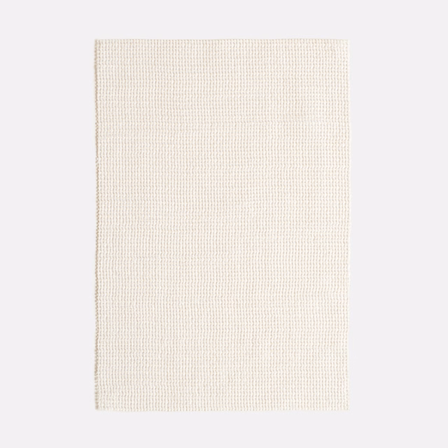 Close view of warm ivory fabric with a fine regular woven grid texture