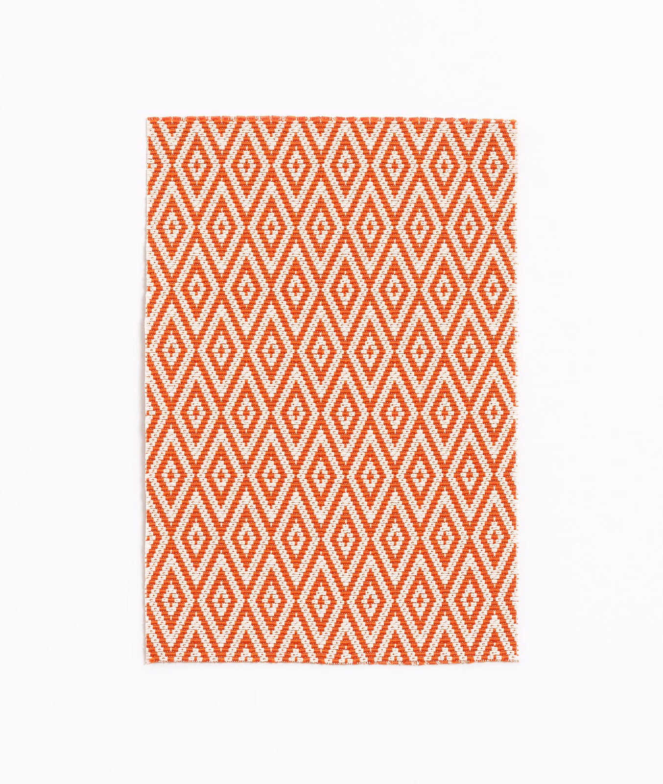 Clementine orange and white woven fabric with repeating diamond motifs