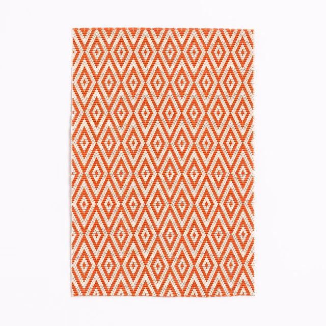 Clementine orange and white woven fabric with repeating diamond motifs