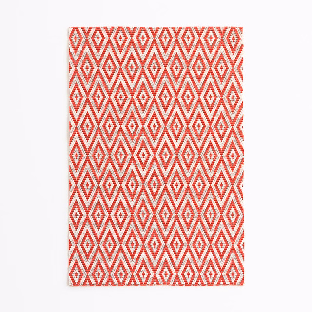 Coral-red and white woven geometric diamond pattern on a rectangular fabric swatch
