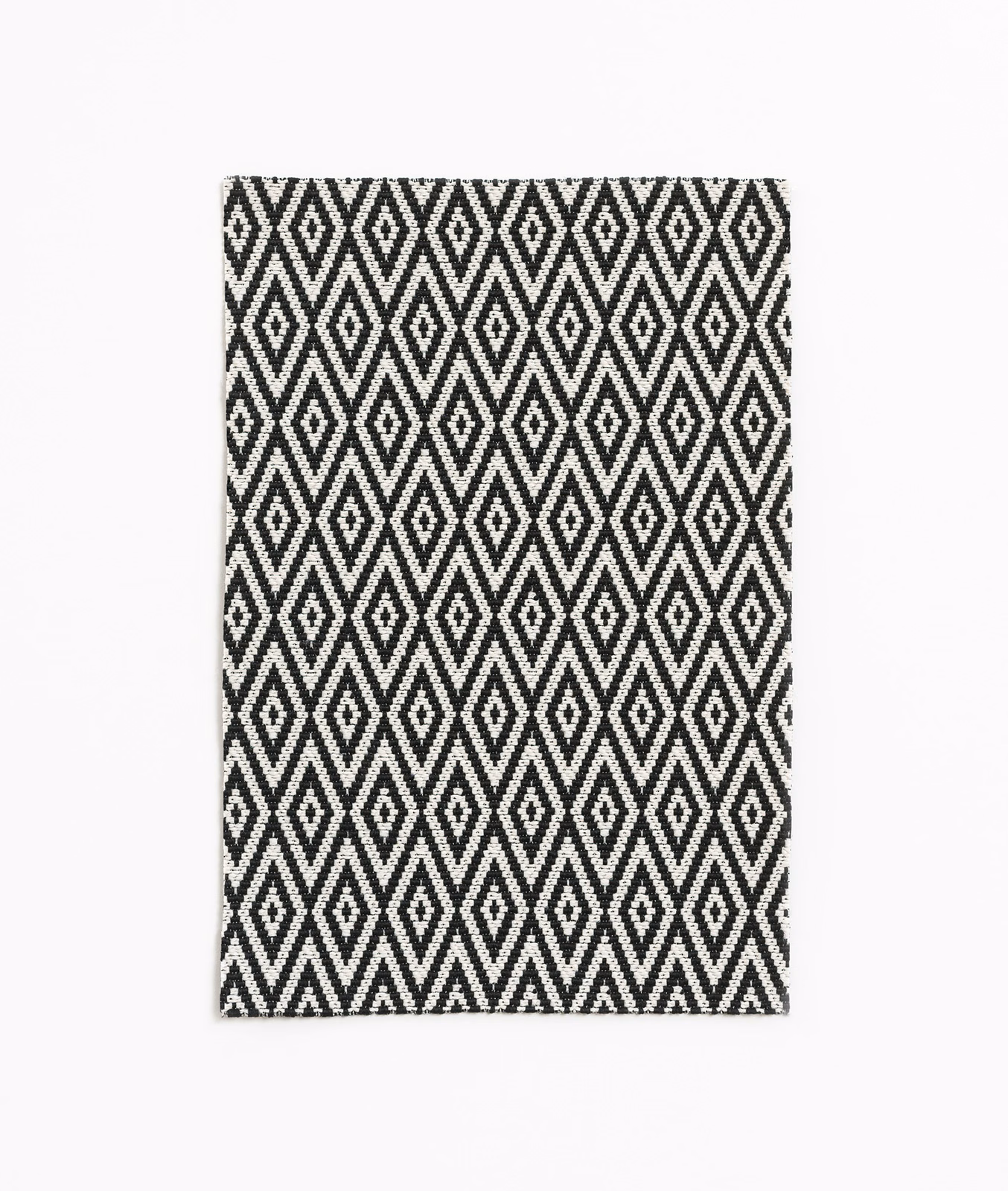 Black and white woven fabric with repeated vertical diamond and zigzag motifs