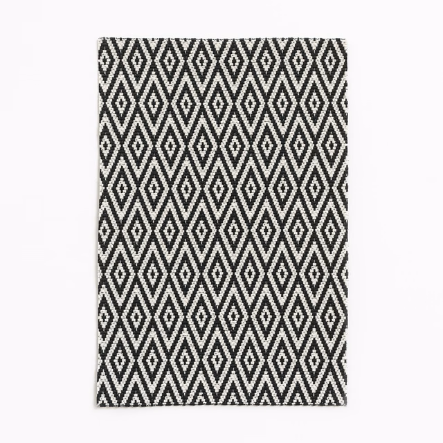 Black and white woven fabric with repeated vertical diamond and zigzag motifs