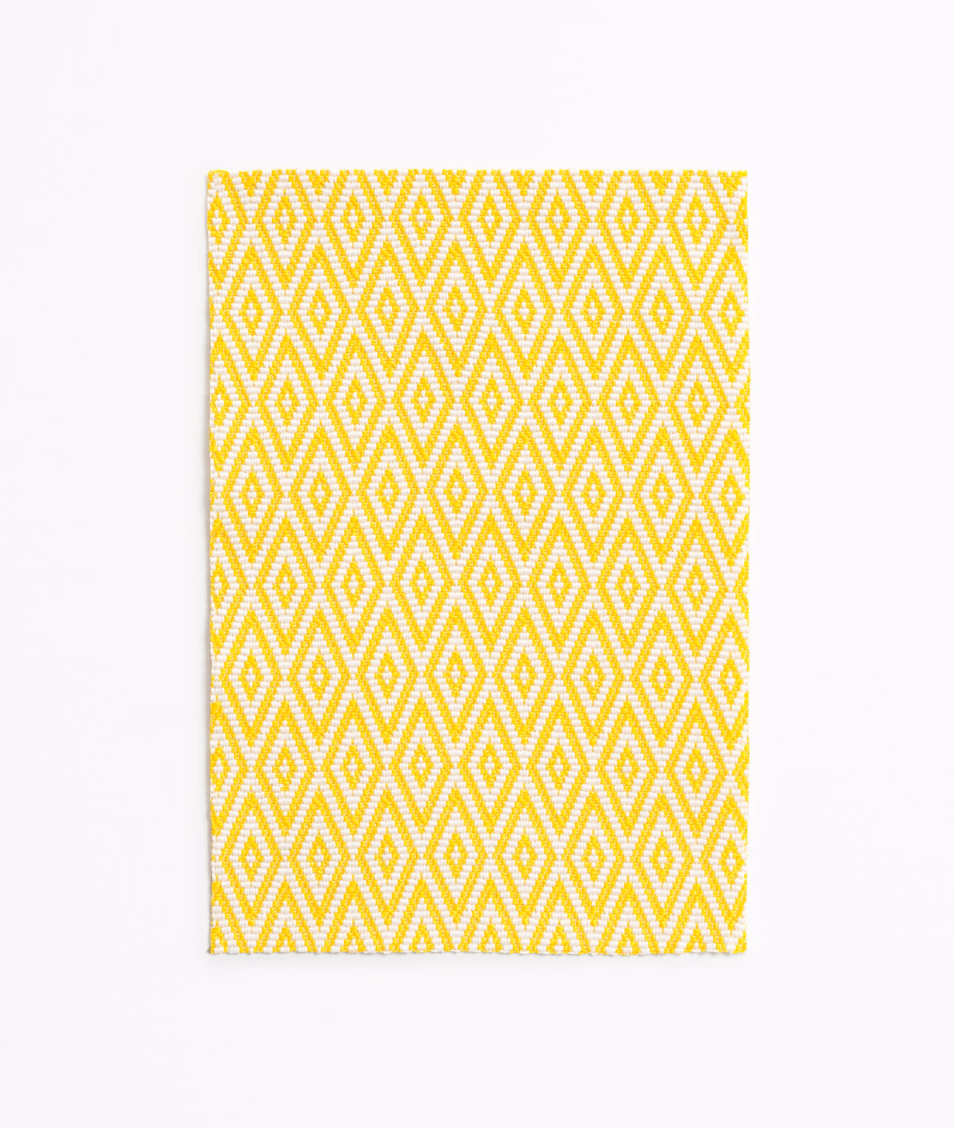 Lemon yellow and white woven fabric with repeating diamond and zigzag geometry