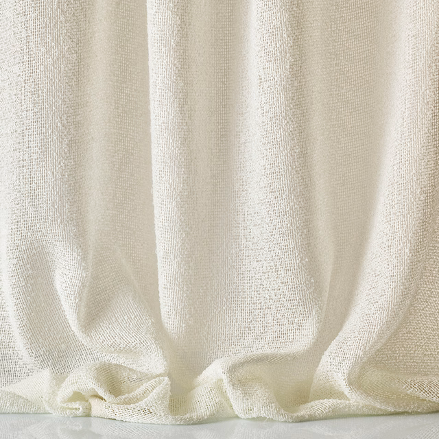 Warm ivory open-weave fabric gathered into softly shadowed vertical folds