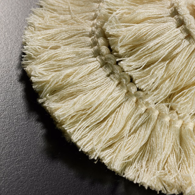 Warm ivory woven fringe with raised knotted bands and softly irregular texture