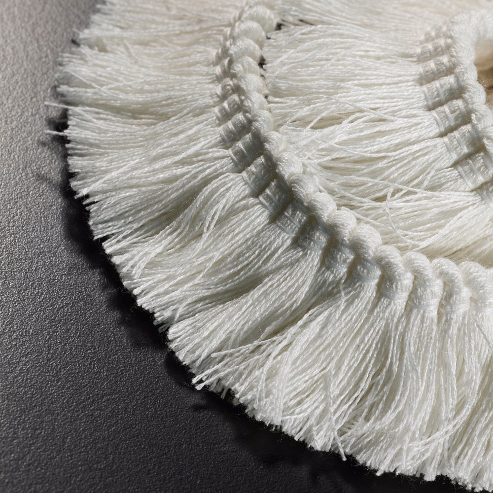 Soft ivory braided fringe with long fine strands in close-up